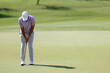 © Teran - Close up golfer legs approach golf ball putting on the green. Lifestyle and Sport Concept.