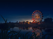 Old Carnival With A Ferris Wheel On A Cloudy Night. 3D Rendering, Illustration