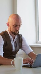 Work stress. Difficult communication. Disturbed angry. Aggressive employee. Overworked man typing laptop meeting problems annoying going away to window workplace interior vertical.