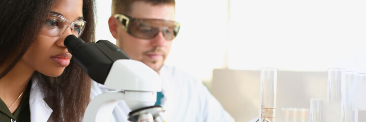 A black woman and a white man are working in the laboratory