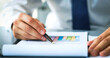 © ty - Close-up of graphs and charts analyzed by businessman