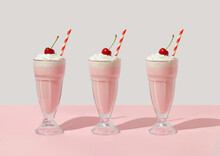 Retro romantic creative pattern with strawberry milkshake with cherry on top on white and pastel pink background. 70s, 80s or 90s retro fashion aesthetic idea. Valentines day romantic idea.