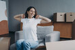 © VK Studio - Happy young woman moves alone. Girl is stretching and going to load packed box.