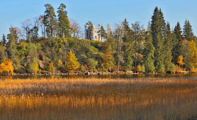 landscape with white turret between autumn trees