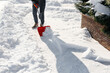 Close-up of a man cleaning and clearing snow in front of the house on a sunny and frosty day. Cleaning the street from snow on a winter day. Snowfall, and a severe snowstorm in winter.