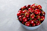 Sweet cherries in bowl. Ripe cherry on a gray background. Freshly picked cherry berries on concrete. Copy space