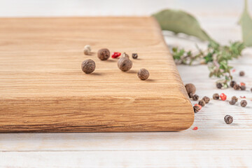 Wall Mural - square wooden cutting board with spices on a white background. mockup with copy space for text, side view, close-up