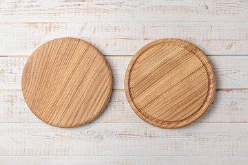 Wall Mural - two round cutting boards with edging on a white wooden table. mockup of a food background with copy space, side view