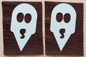 two alien masks on brown and beige paper