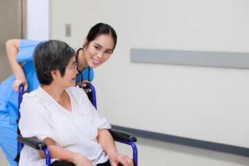 Young asian doctor in blue uniform and senior woman holding hands together. Positive Asian woman caregiver helping patient.