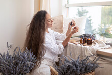 Using Natural Essential Oil In A Home Spa Ritual. A Woman Takes Care Of Her Skin And Hair.