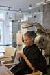 © jul14ka - young woman under hooded dryer machine in hair salon