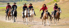 Group Of Cowboy And Cowgirl Ride Horse On Road With High Speed Near Water Reservoir With Day Light.