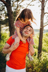 Wall Mural - Family time. Father and little daughter together. He tickles her, and she laughs. They are dressed in sweaters. Leisure.