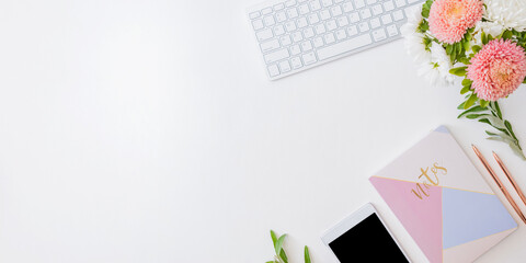 Flat lay home office desktop with smartphone, notebook, flowers in a vase, office supplies on a light background. Top view banner background with copy space