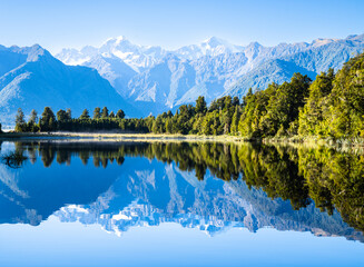 Sticker - Perfect reflection in Lake Matheson surrounded by beautiful natural forest under blue sky