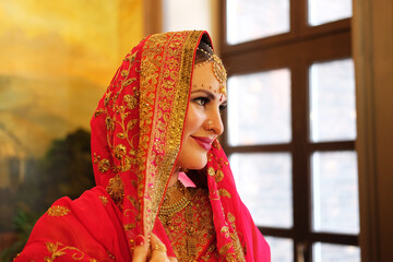Indian wedding. Portrait of attractive Hindu bride with rich jewelry and deep dark eyes