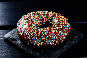 Wall Mural - dark chocolate glazed donut with mixed colorful sprinkle