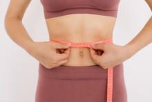 Happy Woman Measures The Ruler Her Belly. The Concept Of Diet And Weight Loss.