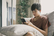 © SewcreamStudio - mixed Asian teen boy using smartphone at home, technology lifestyle concept