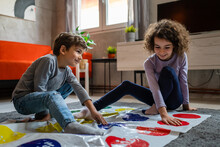 Brother And Sister Siblings Small Caucasian Boy And Girl Child Play Twister Game On The Floor At Home Alone Real People Family Growing Up Leisure Concept Copy Space