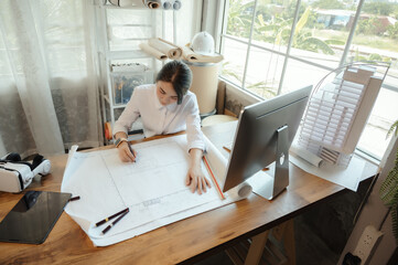 Selective focus, Asian female architect or engineer Drawing the design of the building structure in the blueprint. Asian female architect or engineer Sit and analyze, design projects in the office.