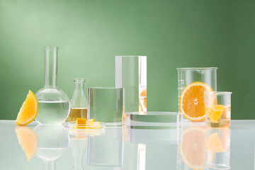 Wall Mural - Front view of orange decorated with glassware and transparent podium in green background 