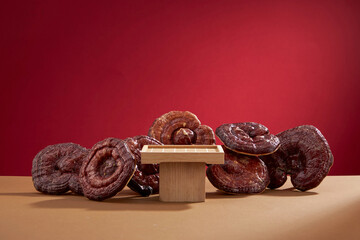 Canvas Print - Front view of lingzhi mushroom in wooden tray and red background