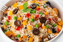 Close Up Of Mixed White And Red Grain Cooked Rice With Fresh Vegetables, Yellow Bell Bebber, Red Tomato, Green Pea, Black Olives And Olive Oil.