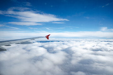 Wall Mural - aircraft wing above beautiful clouds and blue sky