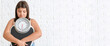 Sad overweight girl with measuring scales on white brick background with space for text. Weight loss concept