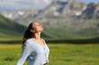 © Antonioguillem - Casual woman breathing fresh air in a green mountain