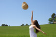 © Antonioguillem - Happy woman throwing hat to air in a wheat field