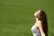 © Antonioguillem - Woman breathing fresh air in a green wheat field