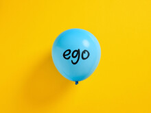 Inflated Blue Balloon With The Word Ego And A Pin. Selfishness Or Inflated Extreme Ego