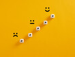 Arrows on wooden cubes pointing from a sad expression towards a happy one. Personal growth and aspiration