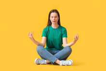 Pretty Young Woman Meditating On Yellow Background