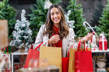 Happy Woman With Bags Full Of Christmas Shopping In Shop