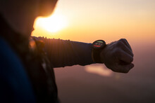Man Checking Smart Watch At Sunset