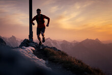 Hiker Running On Top Of Sauling Mountain Peak At Sunset