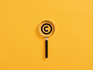 magnifying glass magnifies copyright symbol. patenting or copyright protection.