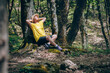 © Westend61 - Woman leaning on tree relaxing in forest