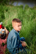 © Westend61 - Thoughtful boy sitting on grass in agricultural field