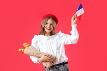 Beautiful Young Woman With Flag Of France And Baguette On Red Background