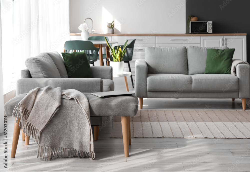 Soft bench with plaid and computer in modern room