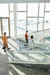 © Westend61 - Businessmen and businesswoman moving down on steps in modern office