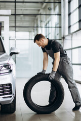 Wall Mural - Workman at car repair shop changing tires