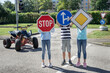 © Westend61 - Children holing road signs in front of face standing on road
