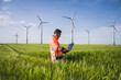 © Westend61 - Engineer using laptop amidst wheat crops near wind turbines on field