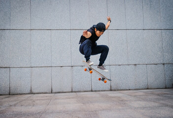 Wall Mural - Asian woman skateboarder skateboarding in modern city